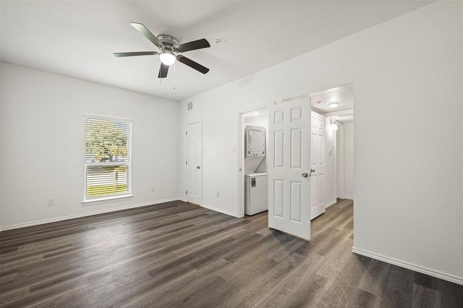 Featuring ceiling fan, dark hardwood / wood-like flooring, and stacked washer and clothes dryer