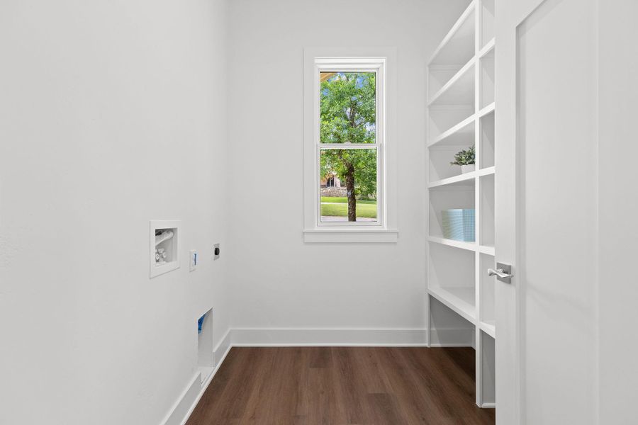 Washroom featuring electric dryer hookup, dark wood-type flooring, hookup for a washing machine, and baseboards Washroom featuring electric dryer hookup, dark wood-type flooring, hookup for a washing machine, and baseboards