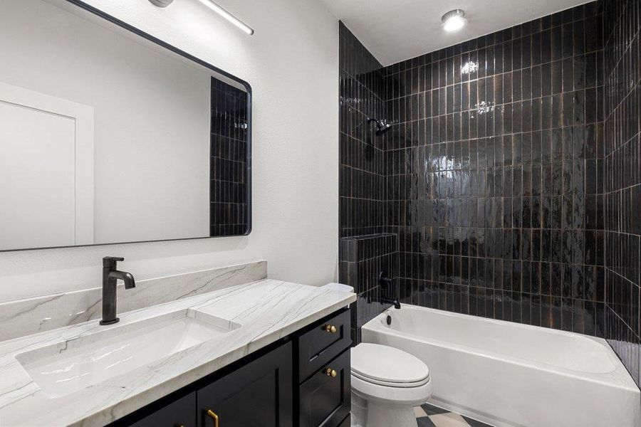 A well-appointed bathroom features a modern vanity with a single sink and a sleek dark tile shower.