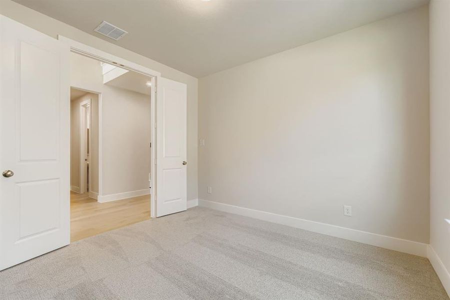 Unfurnished room with light colored carpet and baseboards