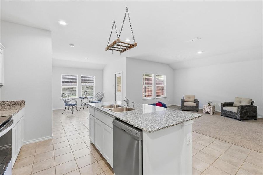 View of living and dining area from kitchen-staged