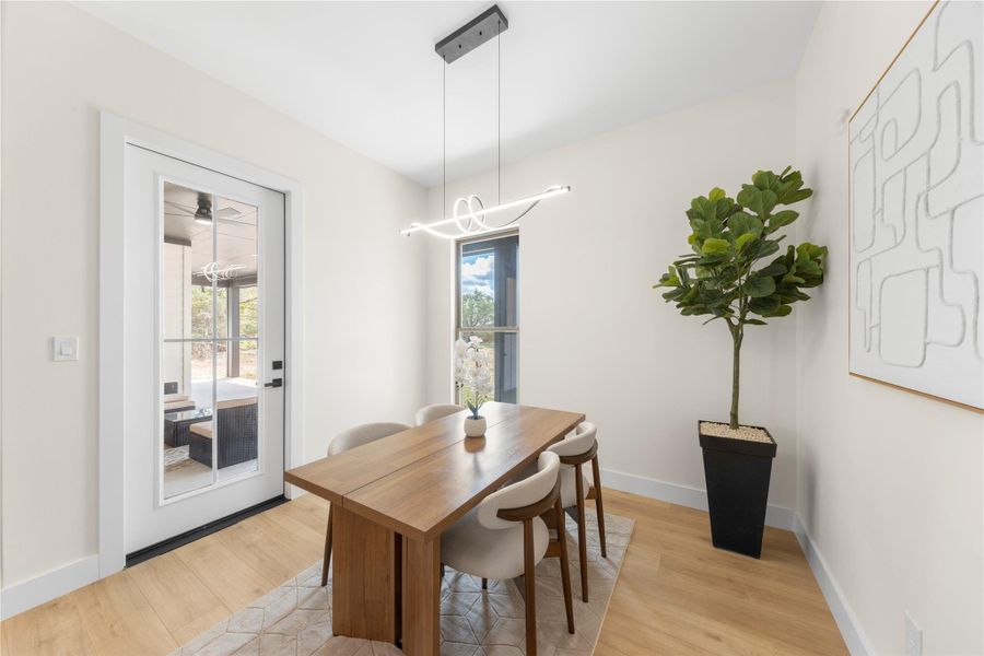 Dining area with light wood-style flooring and a chandelier Dining area with light wood-style flooring and a chandelier