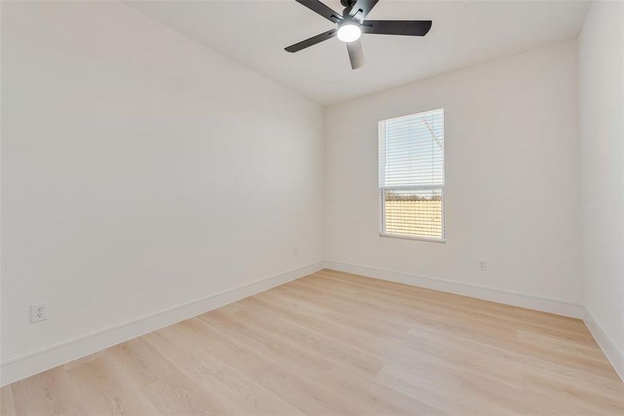 Empty room featuring ceiling fan and light wood-type flooring