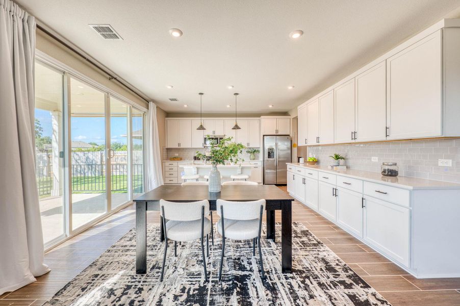 Sliding glass doors merge this modern dining space with the outdoor patio. Sliding glass doors merge this modern dining space with the outdoor patio.