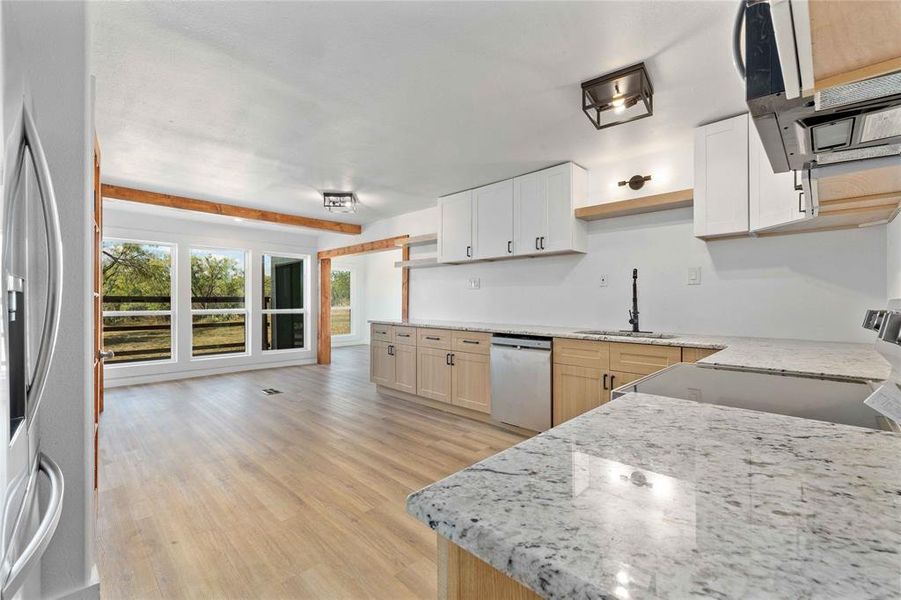 Kitchen featuring open shelves, extractor fan, light wood-style floors, stainless steel appliances, and white cabinets