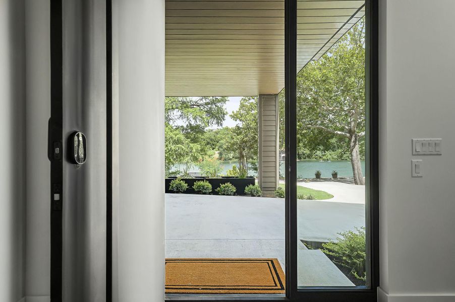 Doorway to outside with a water view and plenty of natural light Doorway to outside with a water view and plenty of natural light