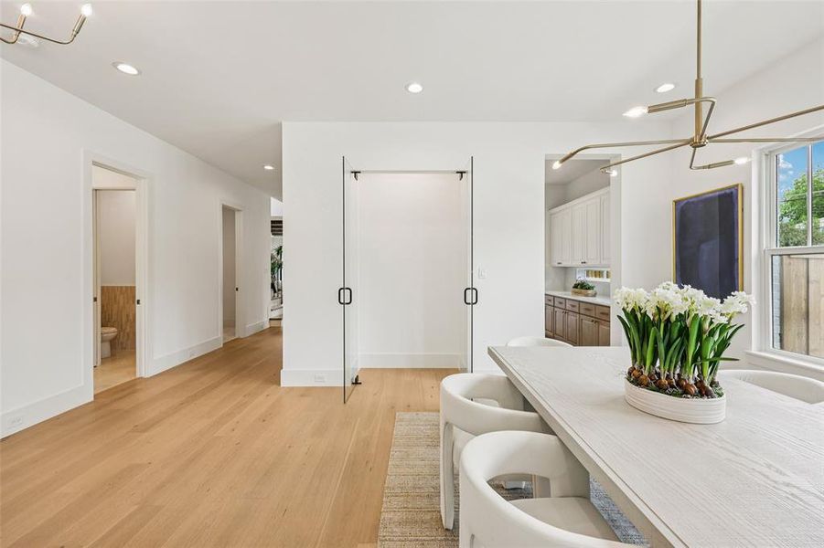 Open concept dining area with light wood-finish flooring