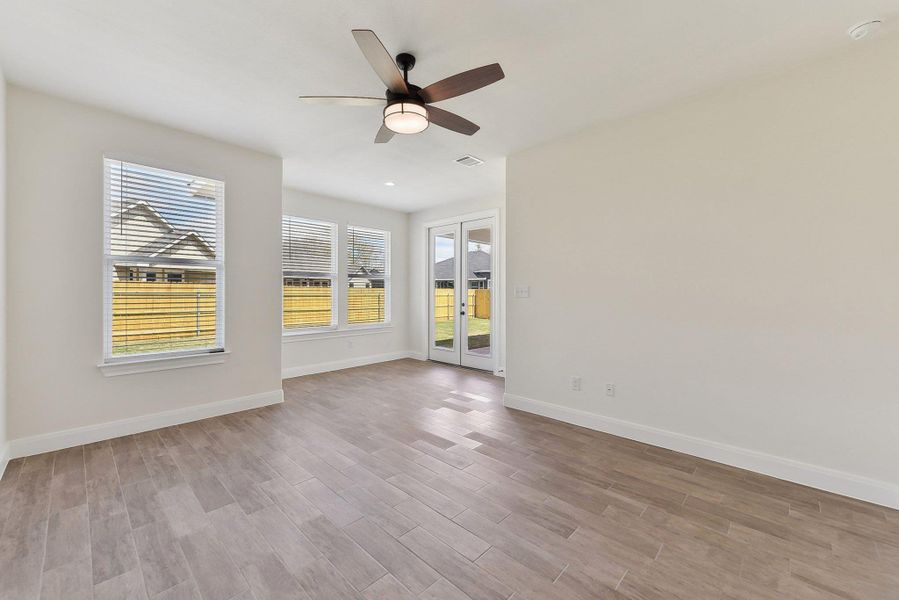 Unfurnished room with visible vents, a ceiling fan, wood finished floors, french doors, and baseboards Unfurnished room with visible vents, a ceiling fan, wood finished floors, french doors, and baseboards