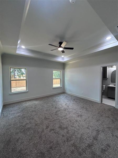 Master bedroom featuring a tray ceiling, a ceiling fan, recessed lighting, and crown molding Master bedroom featuring a tray ceiling, a ceiling fan, recessed lighting, and crown molding