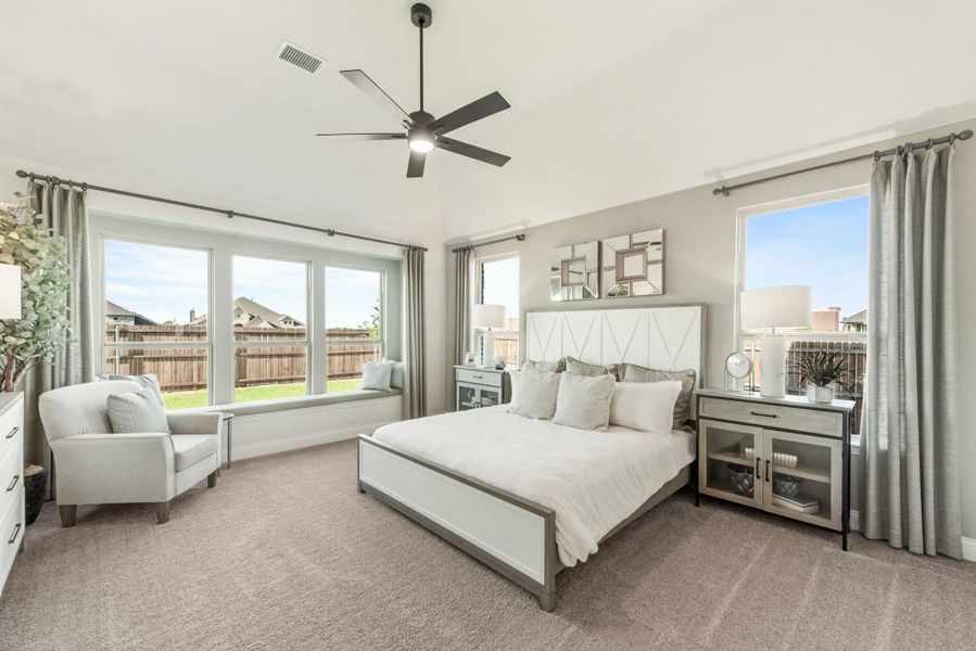 Master bedroom with king bed, ceiling fan, carpet floors, and large windows with window seat