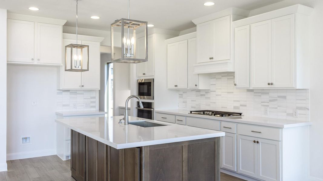 Kitchen with a center island with sink, backsplash, white cabinets, light wood-type flooring, and dark brown cabinetry Kitchen with a center island with sink, backsplash, white cabinets, light wood-type flooring, and dark brown cabinetry