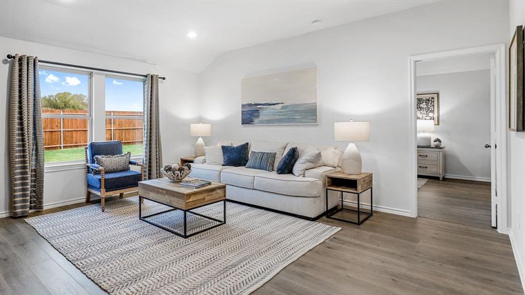 Living area featuring vaulted ceiling, recessed lighting, and wood finished floors Living area featuring vaulted ceiling, recessed lighting, and wood finished floors