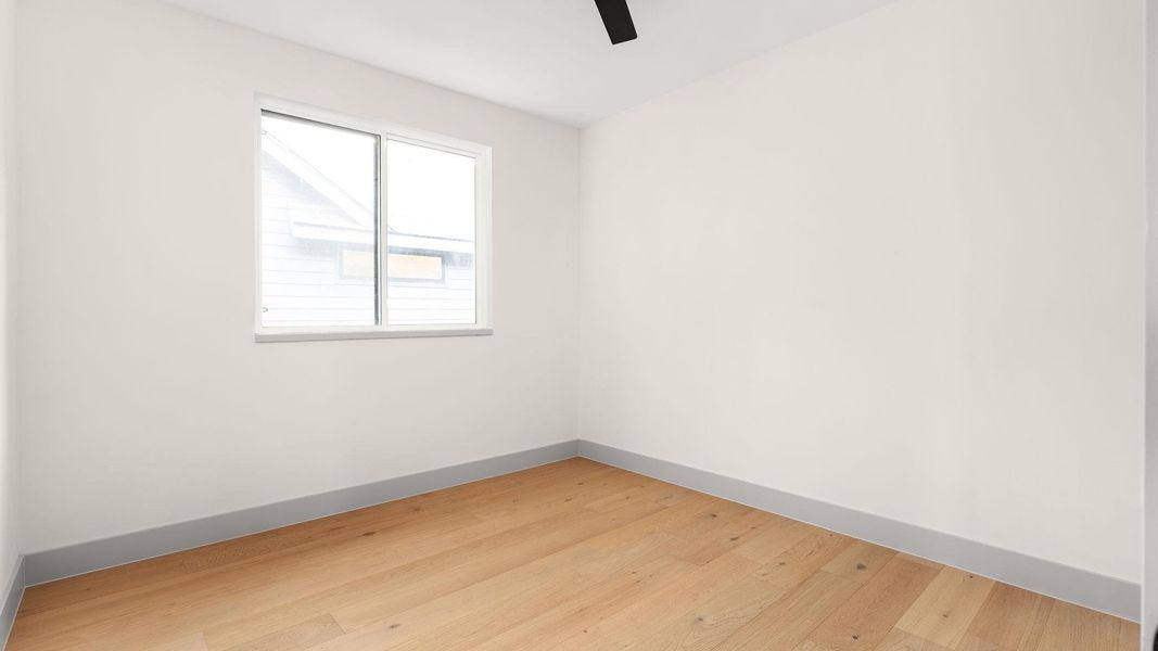 Empty room featuring light wood-style floors and a ceiling fan