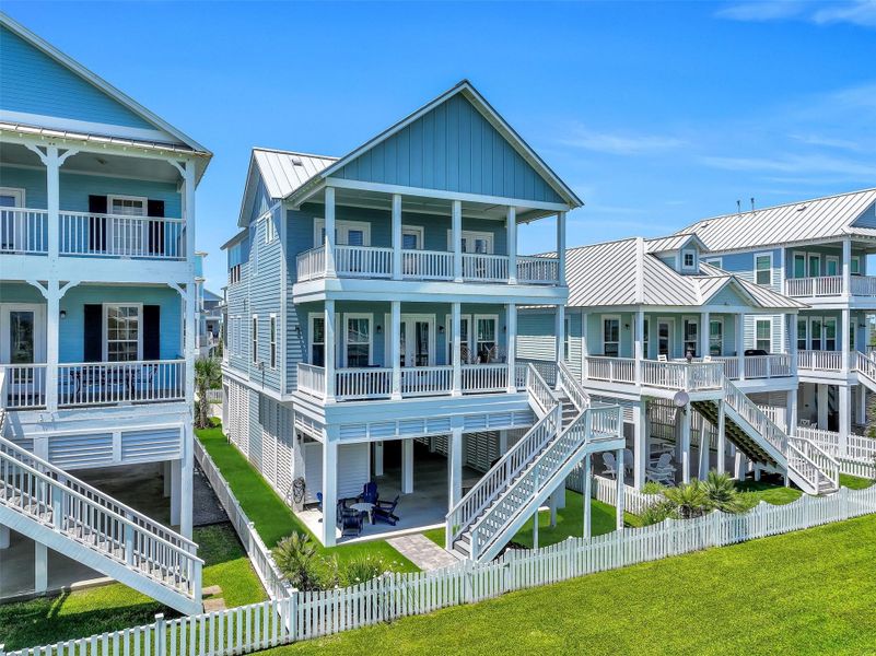 Double balconies and elevated outdoor living create multiple places to relax and enjoy the coastal breeze. The exterior design blends modern beach style with functionality.  The home is located on protected HOA greenspace with a quick walkover to the beach!