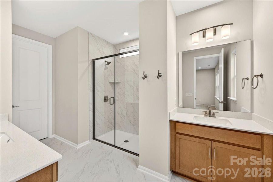 Dual vanity primary bathroom with walk-in tiled shower Dual vanity primary bathroom with walk-in tiled shower