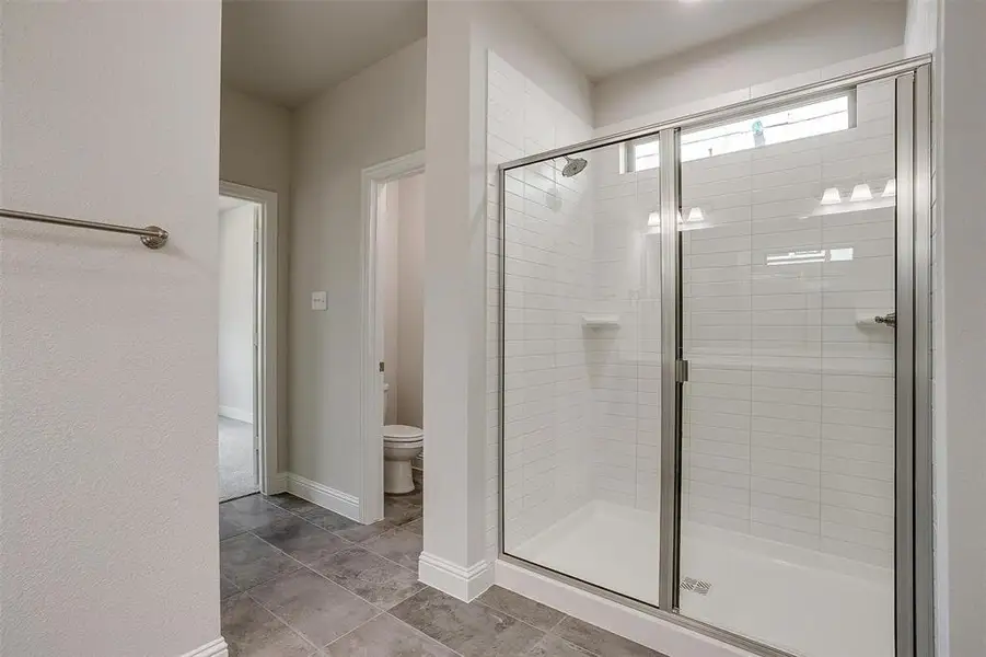 Full bathroom featuring a stall shower and light tile patterned floors