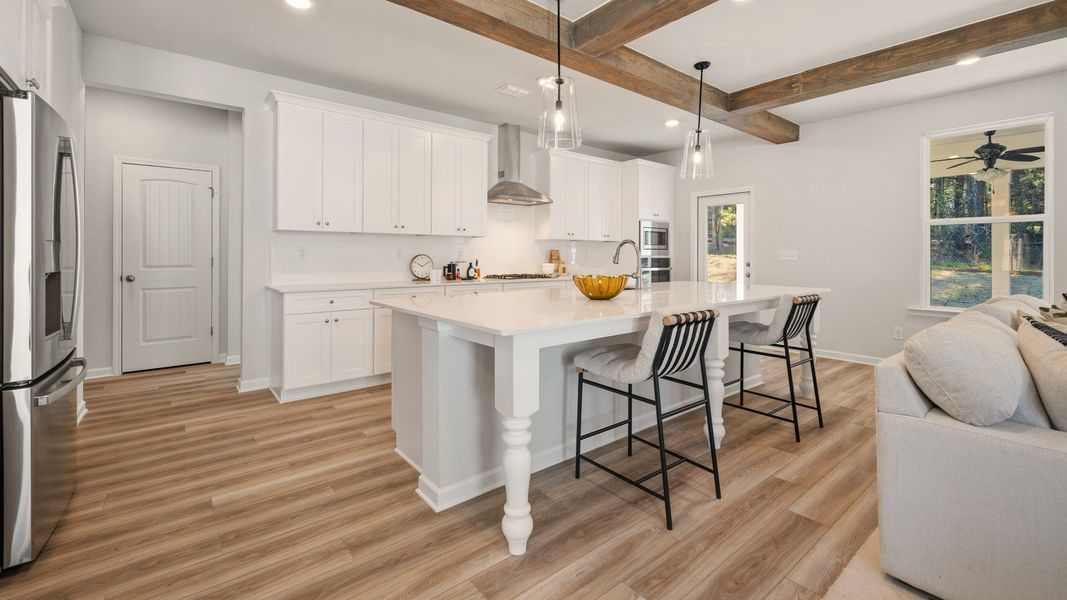 Kitchen with tile backsplash, quartz countertops, and pendant lighting Kitchen with tile backsplash, quartz countertops, and pendant lighting