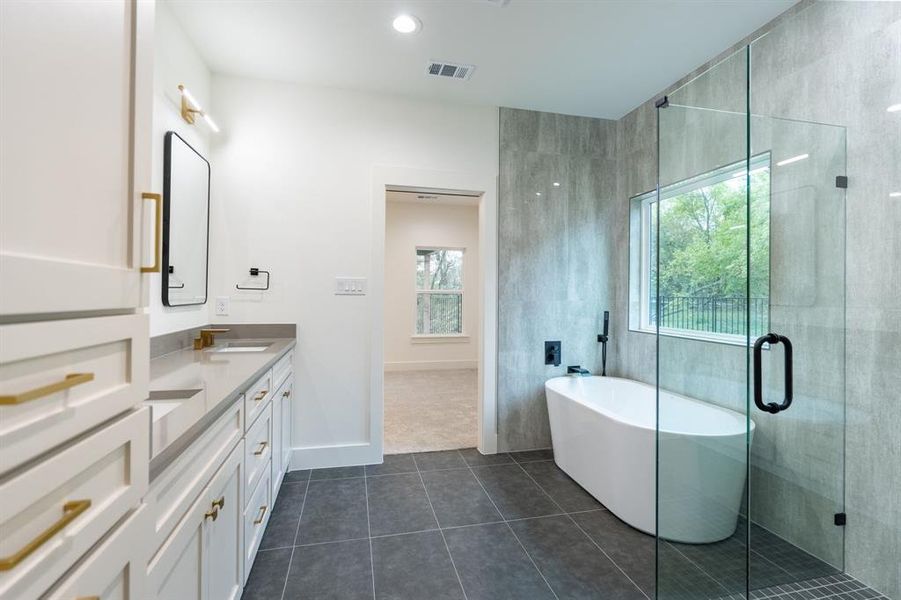 Bathroom featuring plenty of natural light, vanity, tile patterned floors, and independent shower and bath