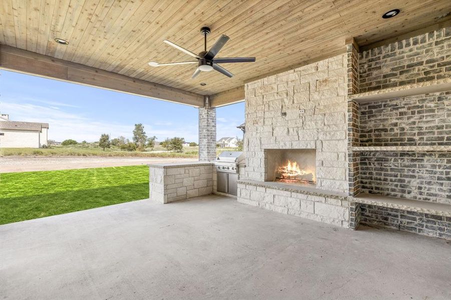 Back Porch Featuring Stone Firewood Storage, Gas Assist Fireplace, and Built In Gas Grill