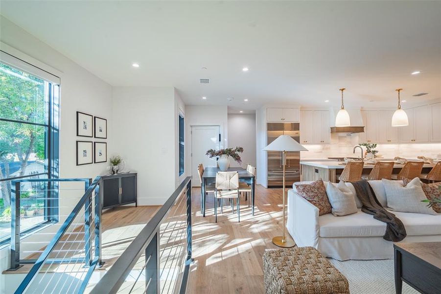 Living room with light hardwood / wood-style floors and sink