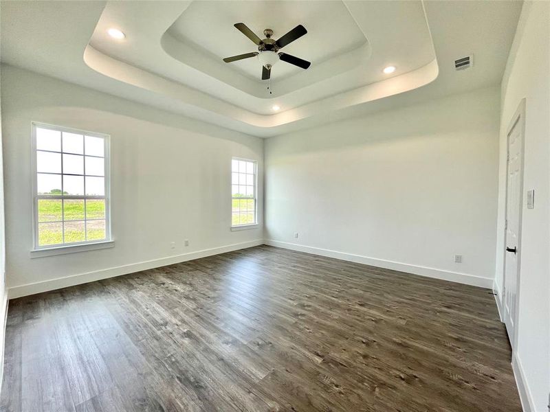 Spare room featuring ceiling fan, baseboards, and dark wood-type flooring Spare room featuring ceiling fan, baseboards, and dark wood-type flooring