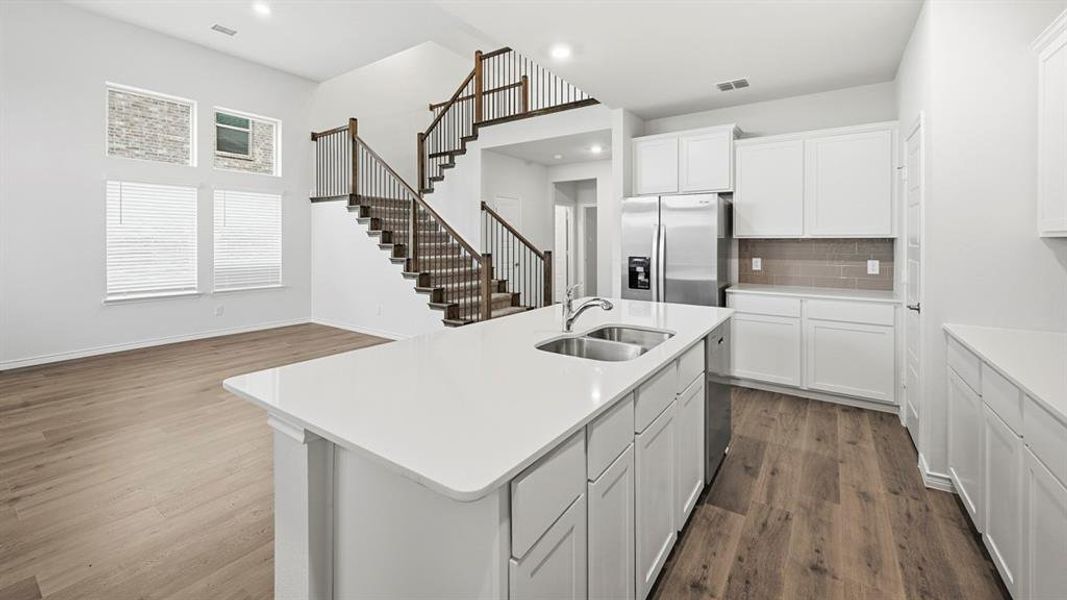Kitchen island with an undermount dual-basin sink, quartz countertop, and integrated dishwasher