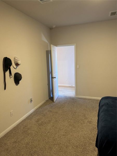 Bedroom featuring light carpet and baseboards