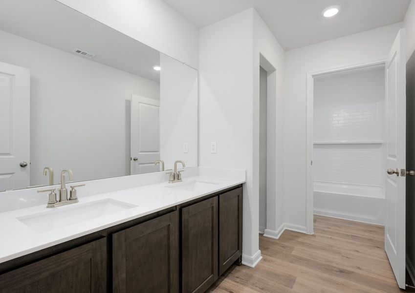 The secondary bathroom has a large vanity space and a shower-tub combo.