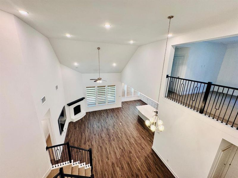 Living room with ceiling fan, vaulted ceiling, and dark hardwood / wood-style flooring