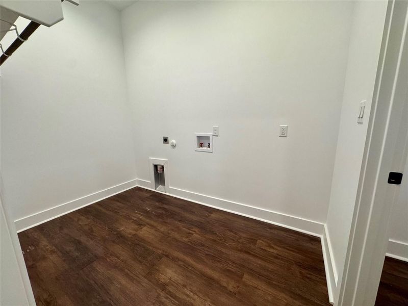 Laundry area with dark wood-type flooring, hookup for a washing machine, electric dryer hookup, and hookup for a gas dryer Laundry area with dark wood-type flooring, hookup for a washing machine, electric dryer hookup, and hookup for a gas dryer