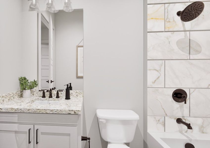 A modern bathroom with a tiled shower, black fixtures and a granite countertop vanity.