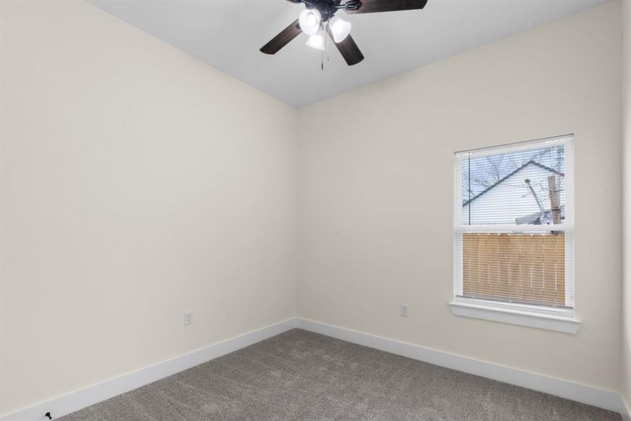 Carpeted spare room with ceiling fan