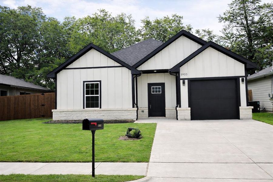 Modern farmhouse exterior featuring vertical white siding with black trim accents Modern farmhouse exterior featuring vertical white siding with black trim accents