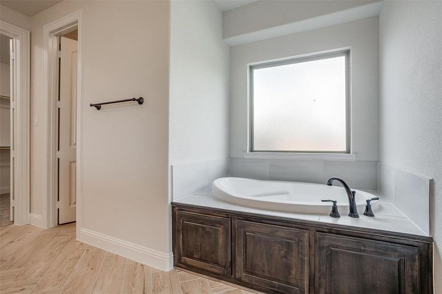 Bathroom with hardwood / wood-style flooring and a bath