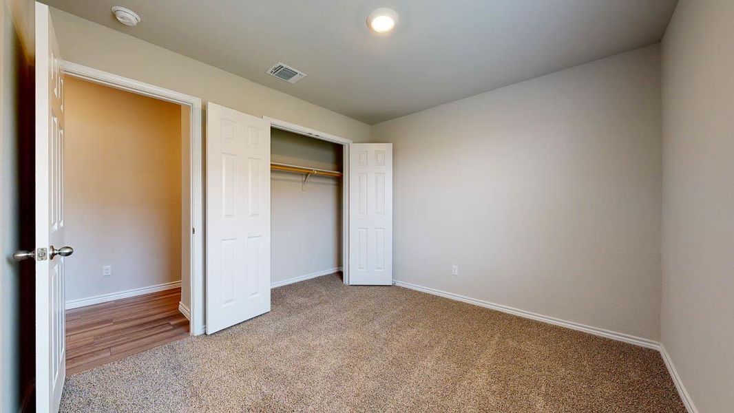Carpeted bedroom with neutral wall tones and a ceiling-mounted light fixture