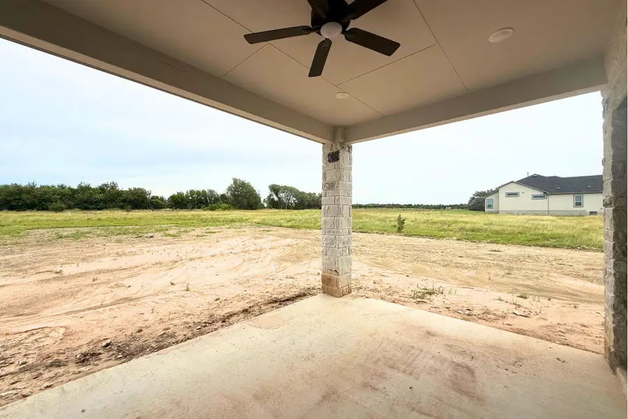 A spacious covered patio provides a serene outlook over an expansive, undeveloped landscape. A spacious covered patio provides a serene outlook over an expansive, undeveloped landscape.