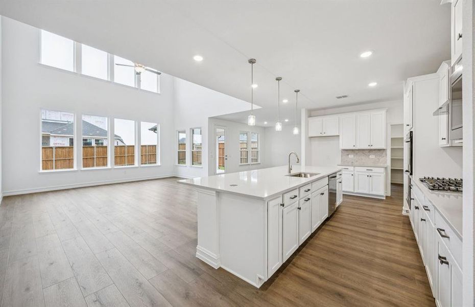 Large island overlooking gathering room and dining areas