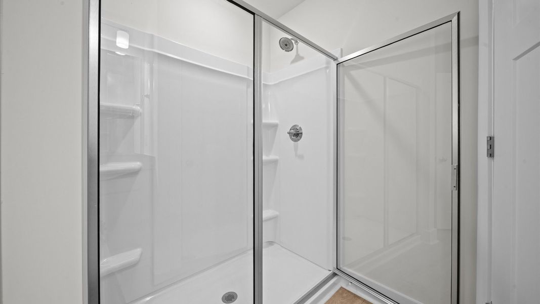 Accomplished design shines in this primary bath with dual vanity and a sleek walk-in shower Accomplished design shines in this primary bath with dual vanity and a sleek walk-in shower