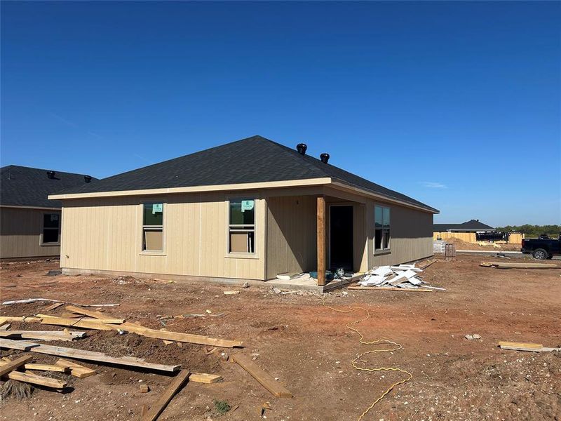 Rear view of house featuring a shingled roof and a patio area Rear view of house featuring a shingled roof and a patio area