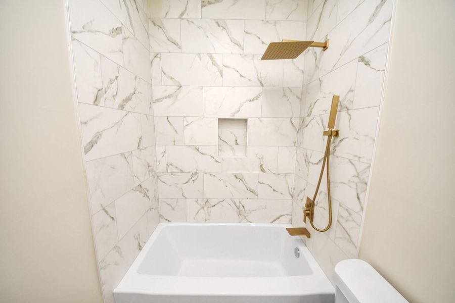 The second full bath features a soaking tub with modern rain/hand shower and contemporary tile accents.