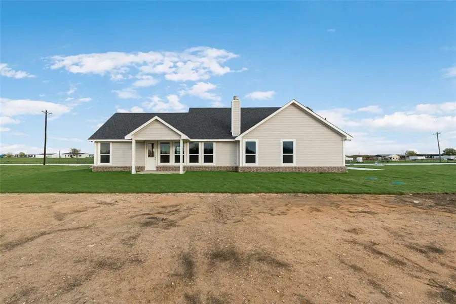 View of front of house featuring a front lawn, a chimney, and a shingled roof