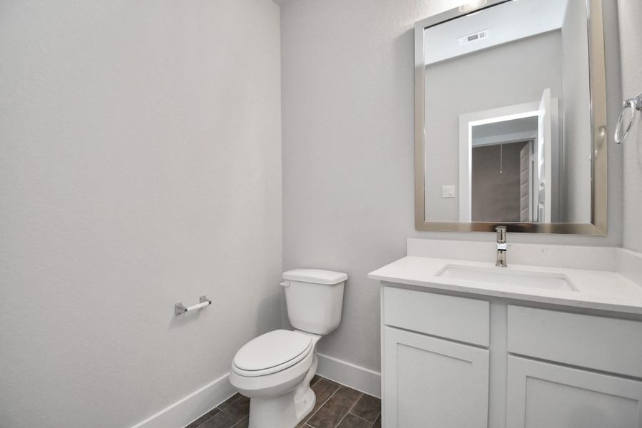 This half bathroom features a stylish pedestal sink, modern hardware, and bright recessed lighting, creating a sleek and inviting space. Sample photo of completed home with similar floor plan. Actual colors and selections may vary. This half bathroom features a stylish pedestal sink, modern hardware, and bright recessed lighting, creating a sleek and inviting space. Sample photo of completed home with similar floor plan. Actual colors and selections may vary.
