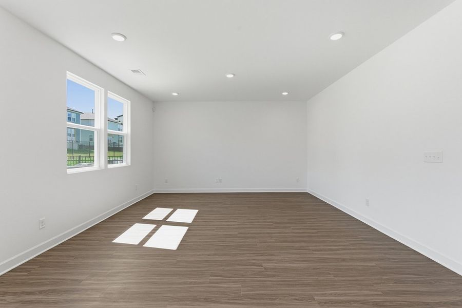 A room with a wood floor and windows.