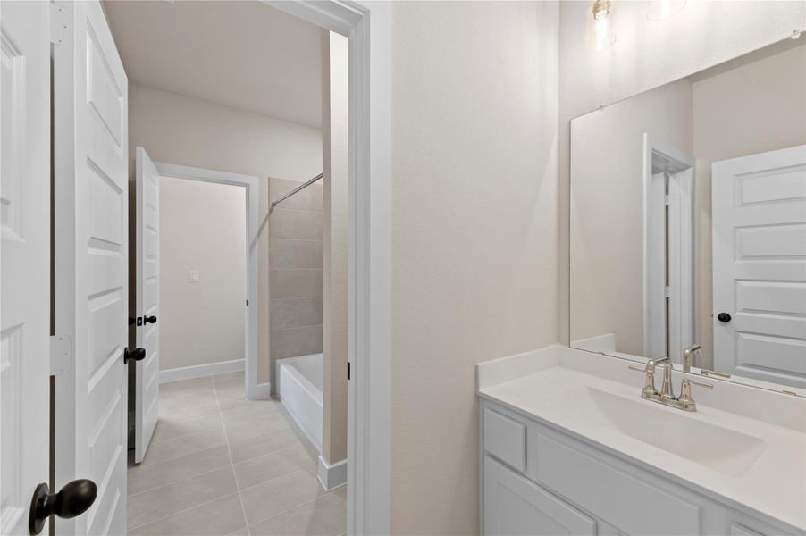 Bathroom with vanity, shower / tub combination, and light tile patterned floors Bathroom with vanity, shower / tub combination, and light tile patterned floors