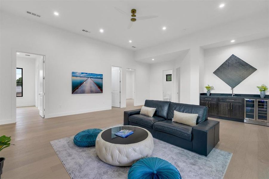 Living room featuring wine cooler, a ceiling fan, light wood-type flooring, and recessed lighting