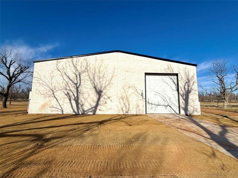 View of outdoor structure with a garage and driveway View of outdoor structure with a garage and driveway