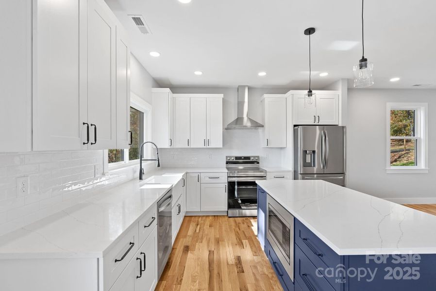Marvel at gorgeous quartz countertops, an expansive island with built in microwave and stainless steel appliances.