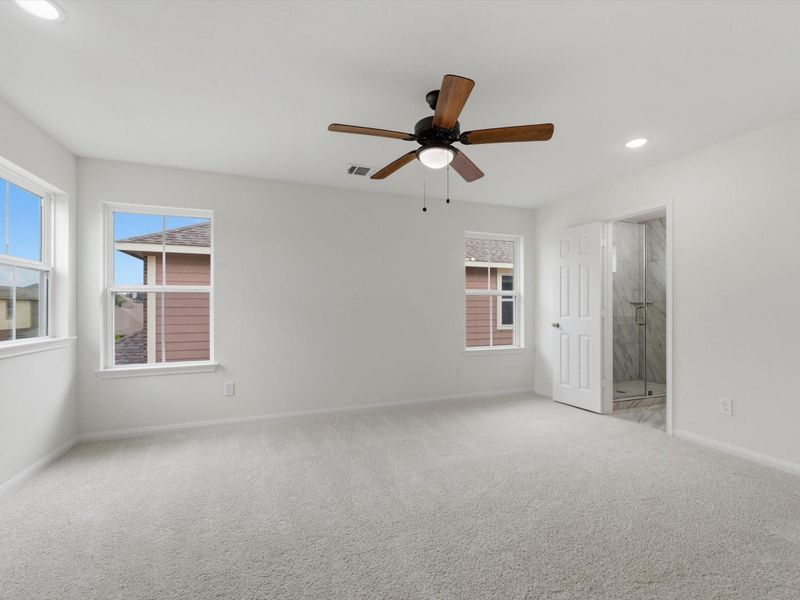 The spacious primary suite offers a peaceful retreat with privacy, comfort, and easy access to the main living spaces.
