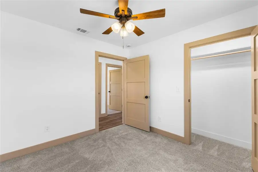 Unfurnished bedroom with carpet flooring, ceiling fan, and a closet