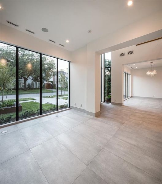 Functional home office that will inspire your productivity with wall of glass panels with amazing front yard views